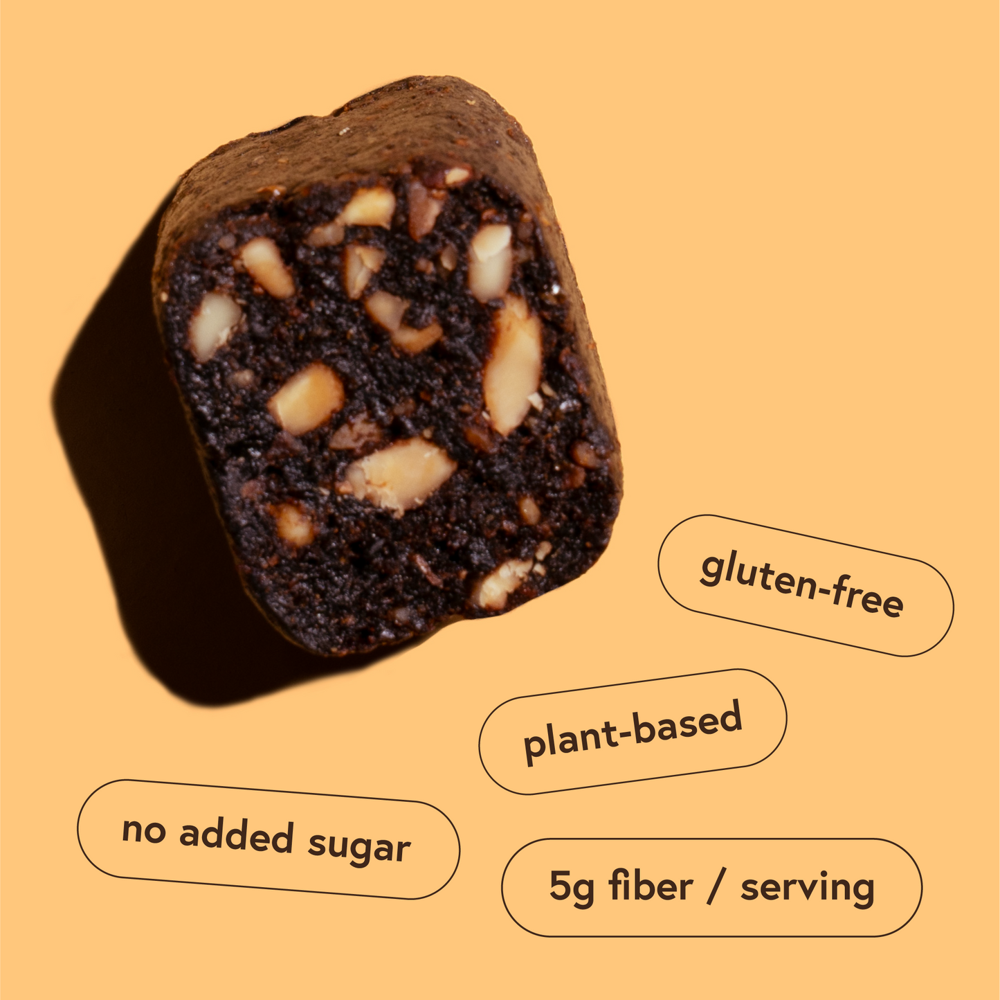 Close-up of a gluten-free, plant-based Fig snack bar with nuts on an orange background