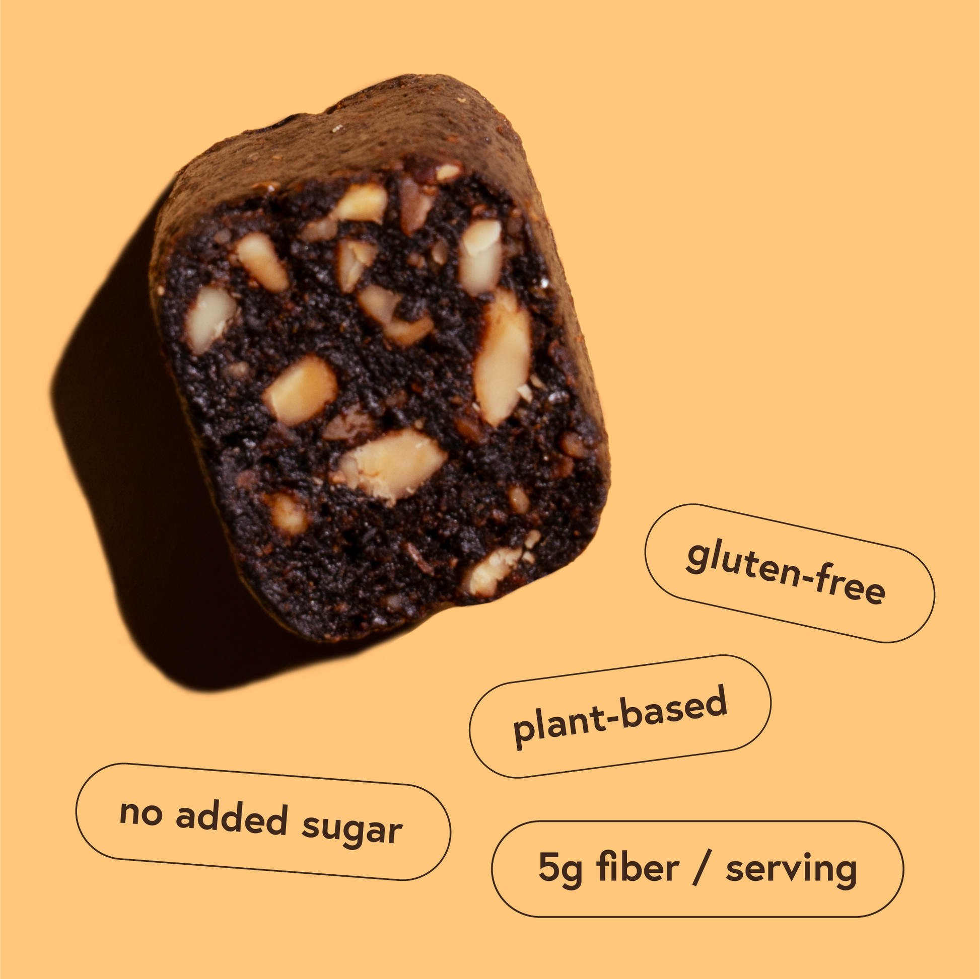 Close-up of a gluten-free, plant-based Fig snack bar with nuts on an orange background