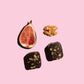 Fichi fig and walnut snack bite next to an opened fig and walnut. 
